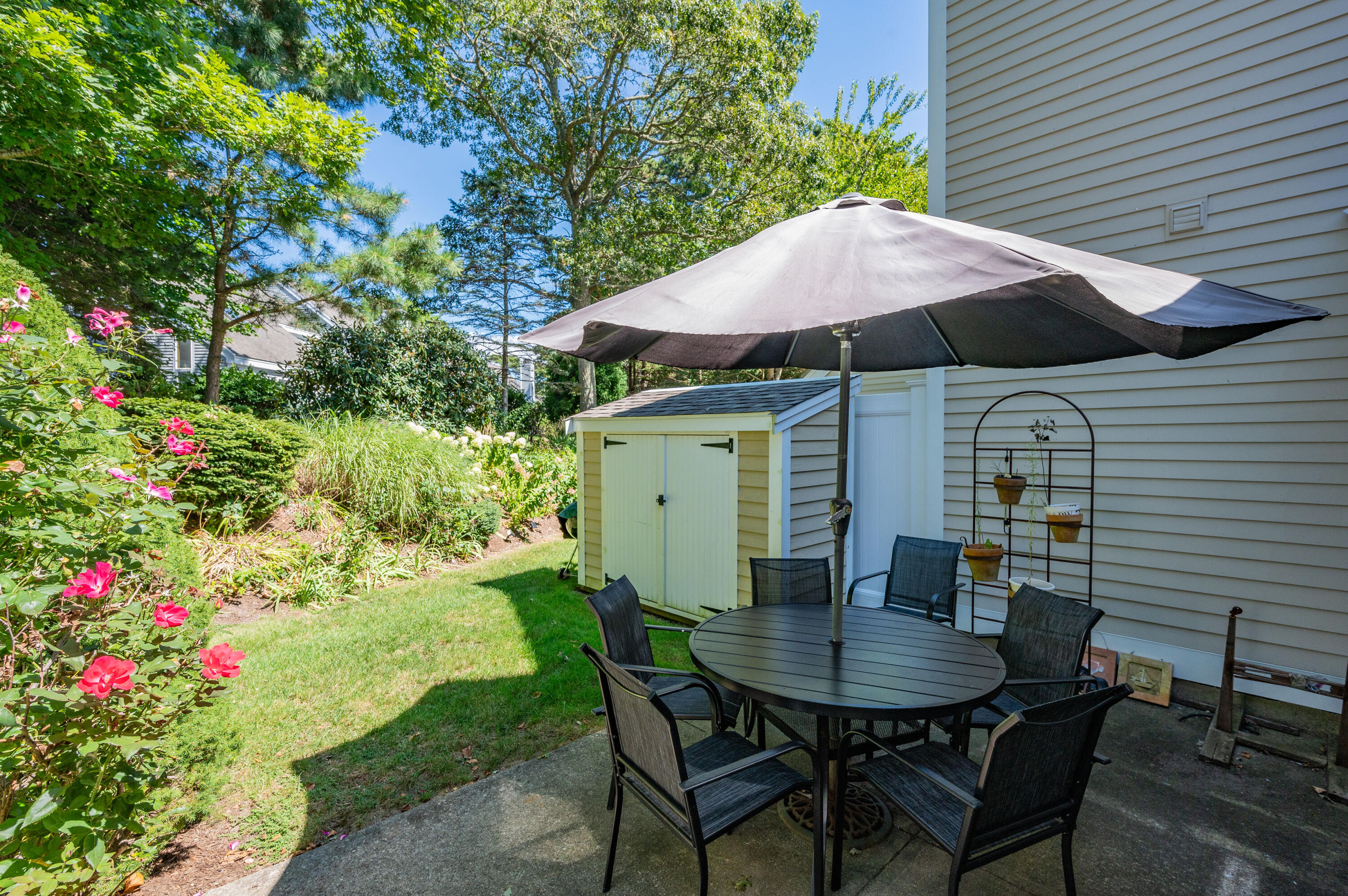 1 Howland Circle Brewster, MA 02631 - Photo 27 of 29 a backyard of a house with table and chairs