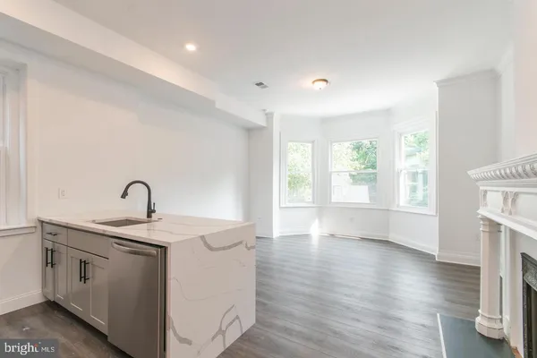 a view of a sink and dishwasher with wooden floor