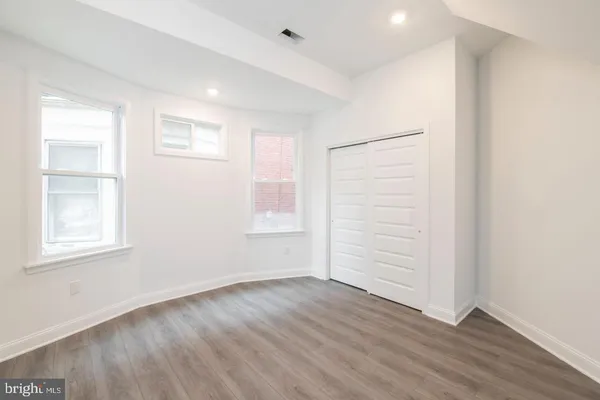 an empty room with wooden floor and white walls
