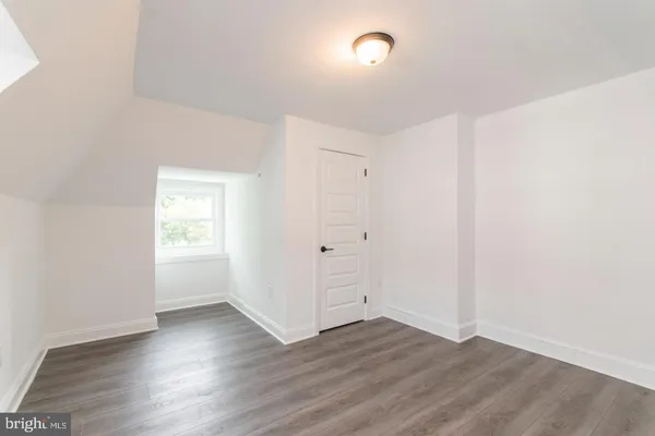 an empty room with wooden floor and white walls