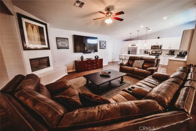 a living room with furniture kitchen view and a flat screen tv