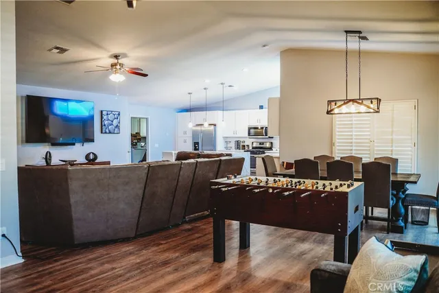 a living room with furniture a chandelier and a flat screen tv