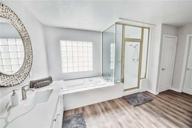 a spacious bedroom with a bed a mirror and a window