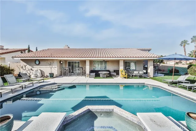 a front view of house and swimming pool with seating space