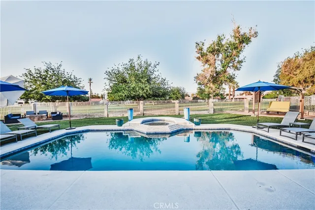 swimming pool view with a seating space and a garden view