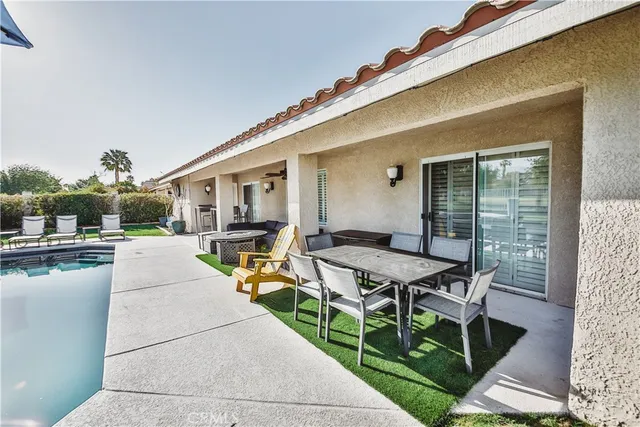 a view of a patio with table and chairs with wooden floor and fence