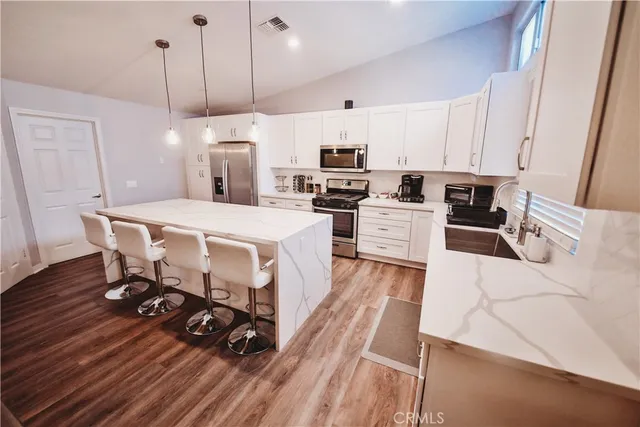 a kitchen with a table chairs stove and white cabinets