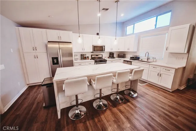 a kitchen with granite countertop a sink appliances a counter space and cabinets
