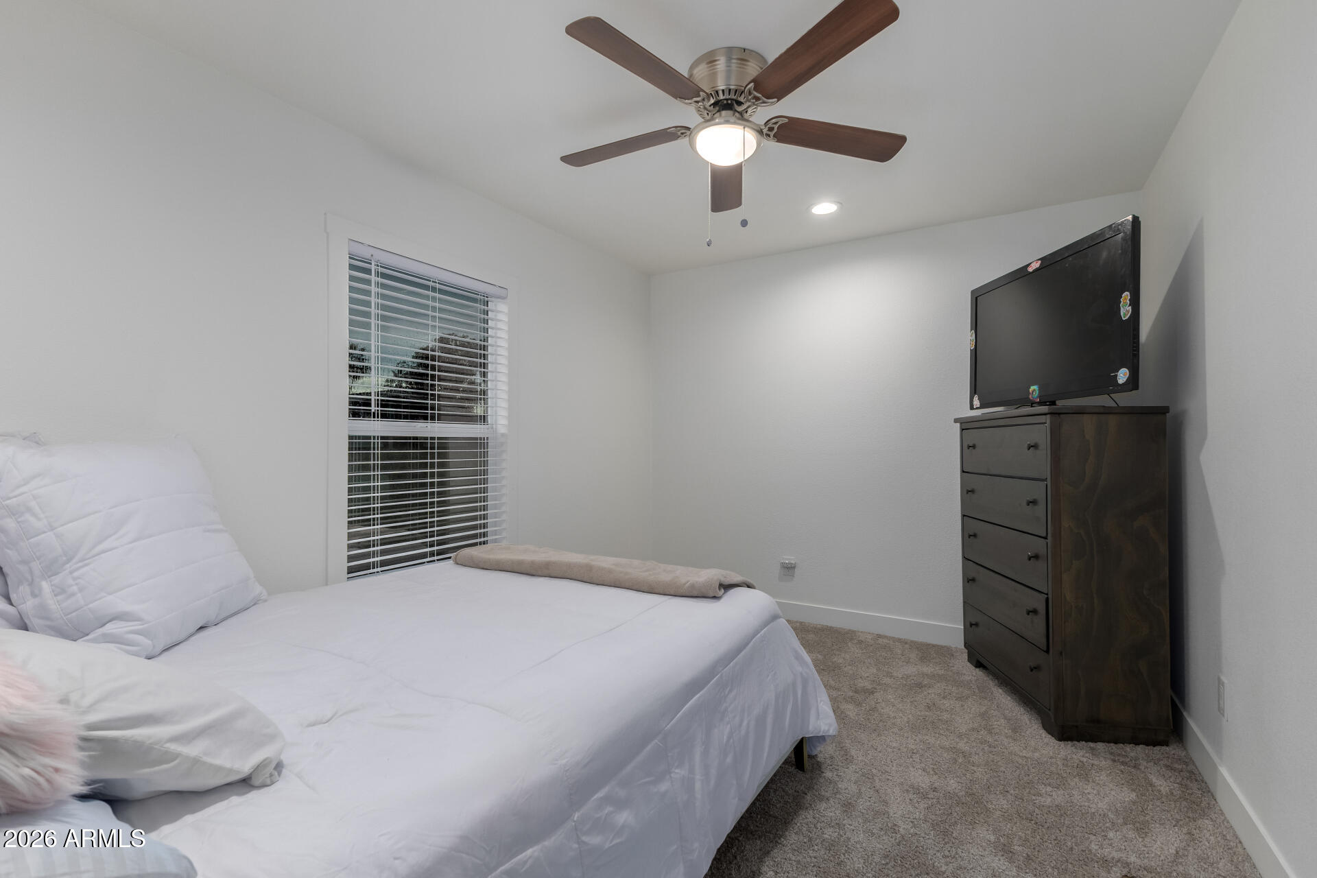 19401 North 7th Street, Unit 73 Phoenix, AZ 85024 - Photo 25 of 30 a spacious bedroom with a bed and a flat screen tv