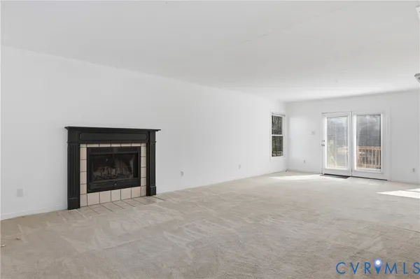 an empty room with a fireplace and large window