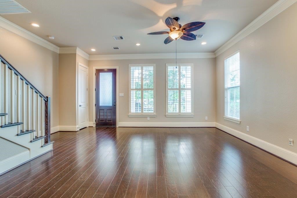 46 East Rafters Row The Woodlands, TX 77380 - Photo 4 of 25 Spacious open-concept living room featuring rich wood flooring, plantation shutters, and abundant natural light.