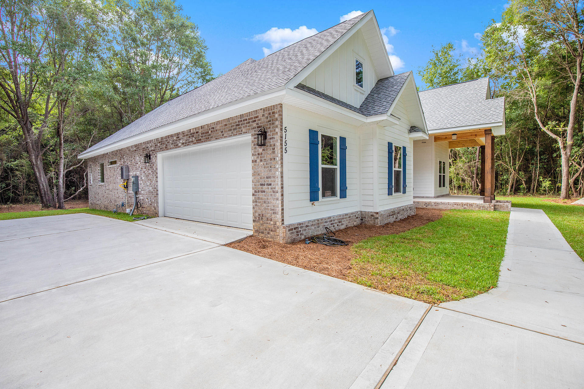 5155 Griffith Mill Road Holt, FL 32564 - Photo 2 of 56 a view of a white house with a small yard and large tree
