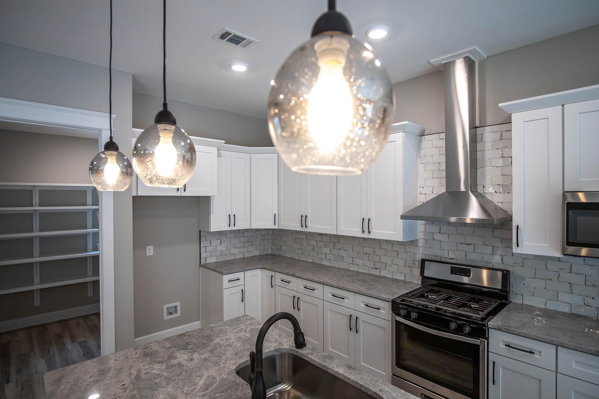 5155 Griffith Mill Road Holt, FL 32564 - Photo 19 of 56 a kitchen with granite countertop a stove a sink and a chandelier