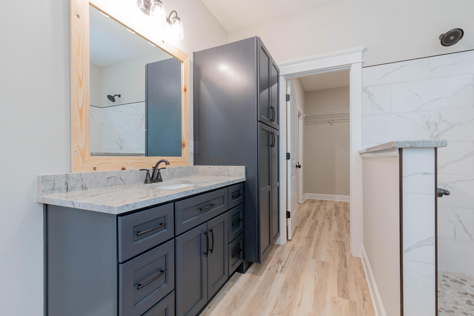 5155 Griffith Mill Road Holt, FL 32564 - Photo 36 of 56 a spacious bathroom with a granite countertop sink a mirror and a shower