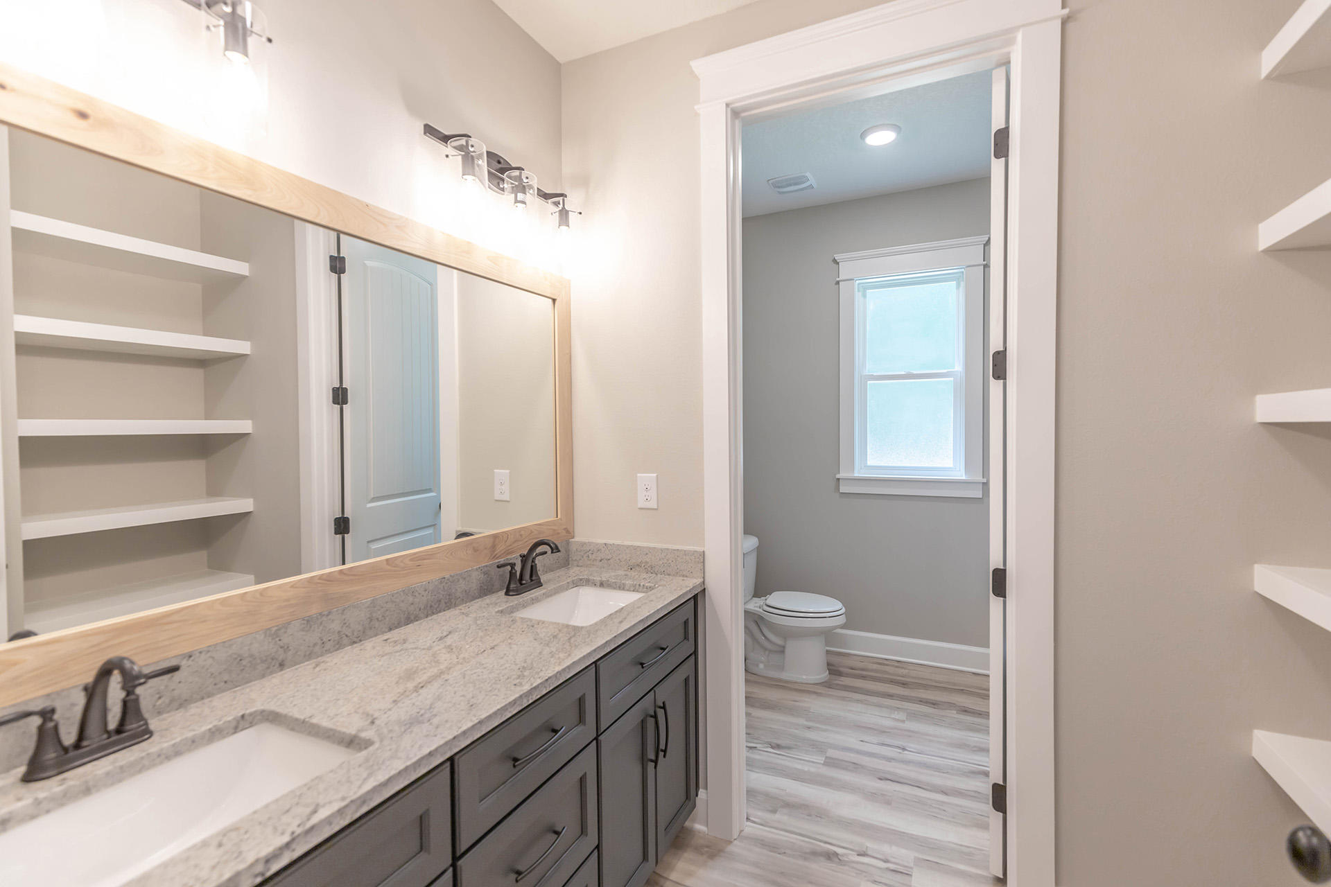 5155 Griffith Mill Road Holt, FL 32564 - Photo 46 of 56 a bathroom with a granite countertop sink a toilet and a mirror