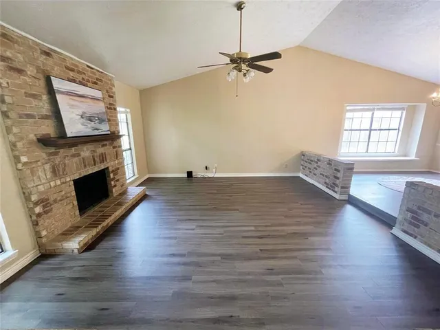 a view of a livingroom with furniture a fireplace wooden floor and chandelier