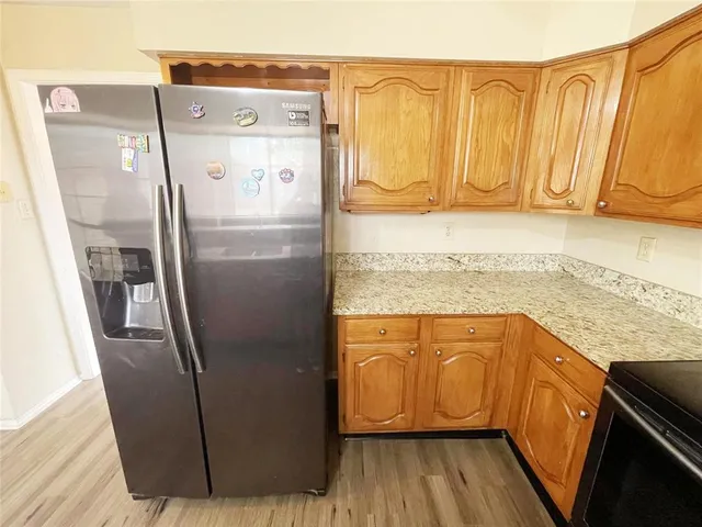 a kitchen with stainless steel appliances granite countertop a refrigerator a sink and dishwasher