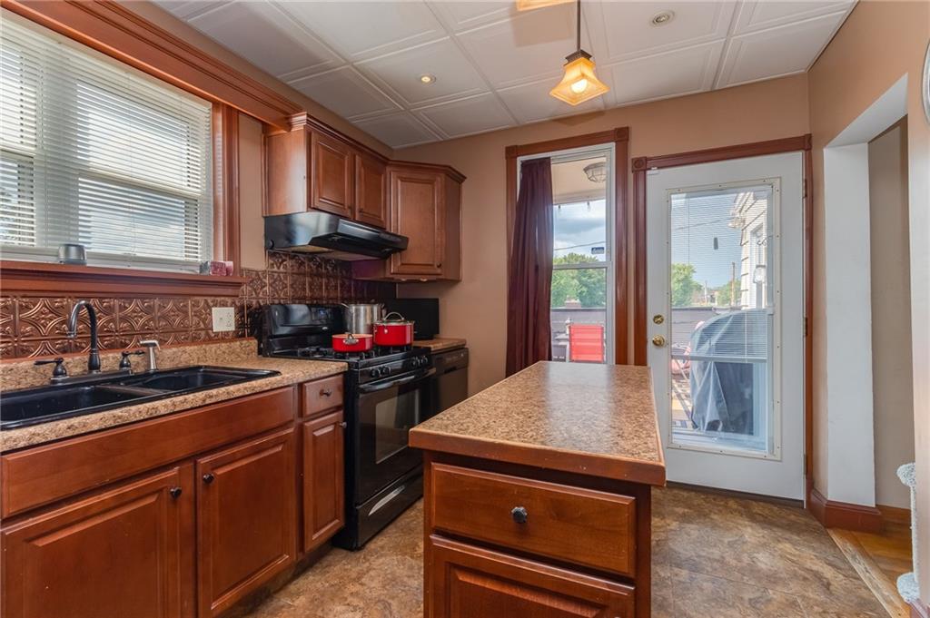 550 Virginia Avenue Rochester, PA 15074 - Photo 9 of 24 a kitchen with kitchen island granite countertop a sink cabinets and wooden floor