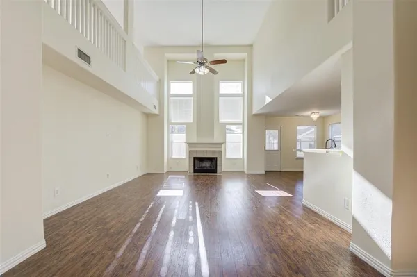 wooden floor fireplace and windows in an empty room