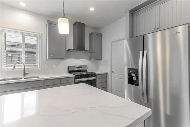 a kitchen with stainless steel appliances a refrigerator sink and stove