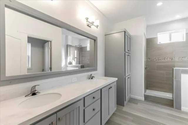 a bathroom with a double vanity sink mirror and shower