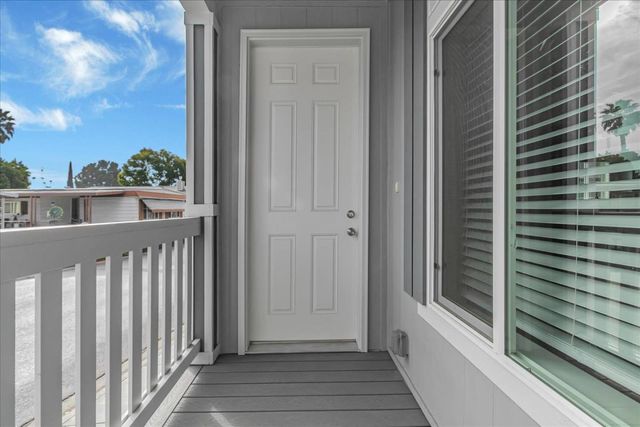 a view of a balcony with wooden floor and fence