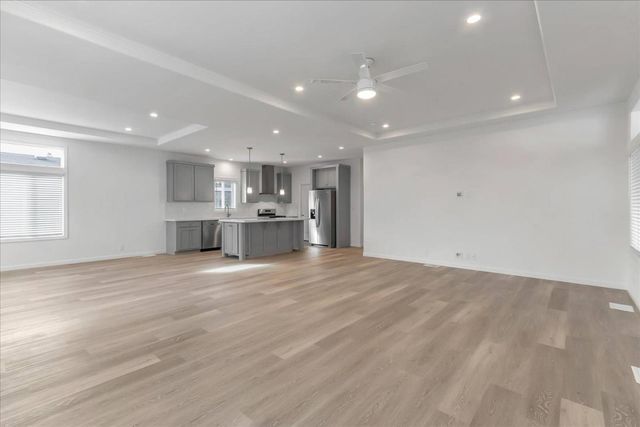 a view of kitchen with kitchen island wooden floor wooden cabinets and stainless steel appliances