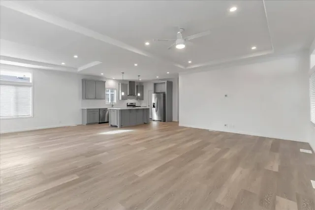a view of kitchen with kitchen island wooden floor wooden cabinets and stainless steel appliances