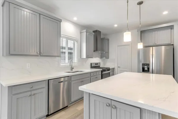 a large kitchen with a sink a refrigerator and window
