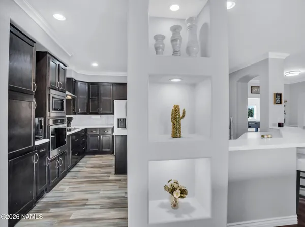 a kitchen with stainless steel appliances a refrigerator sink and wooden floor