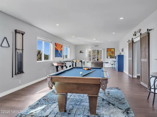 a living room with furniture pool table and a flat screen tv