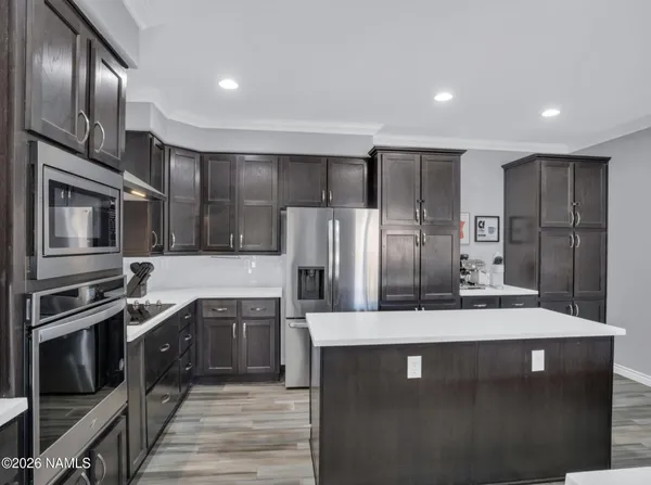 a kitchen with stainless steel appliances kitchen island granite countertop a refrigerator oven a sink and dishwasher