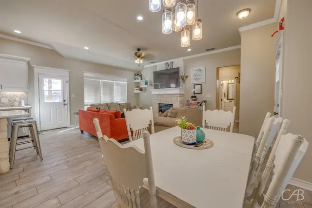 a kitchen with stainless steel appliances wooden floor dining table and chairs