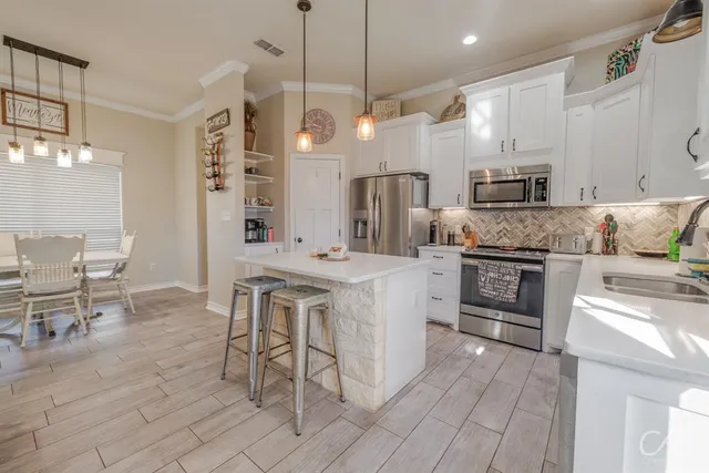 a kitchen with stainless steel appliances kitchen island granite countertop a sink and cabinets
