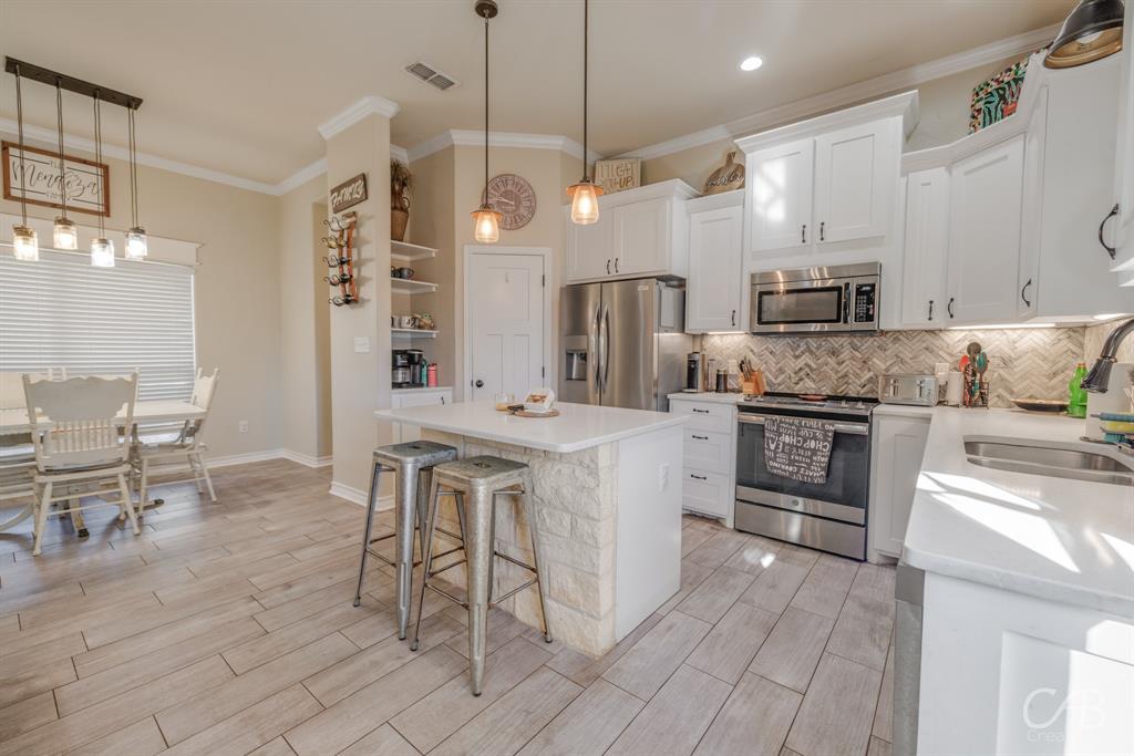 625 Jarrell Court Tuscola, TX 79562 - Photo 10 of 32 a kitchen with stainless steel appliances kitchen island granite countertop a sink and cabinets