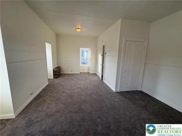 a view of a hallway to a room with windows