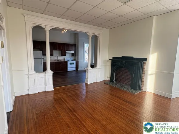 a view of a living room with a fireplace and wooden floor