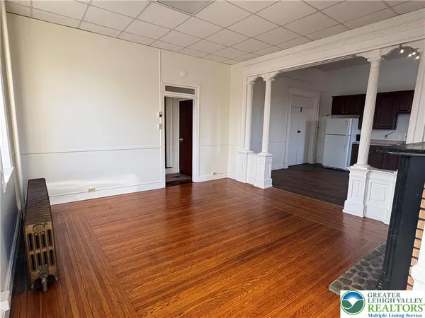 a view of empty room with wooden floor