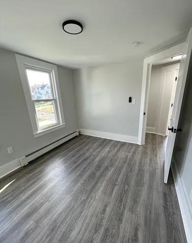 an empty room with wooden floor and window