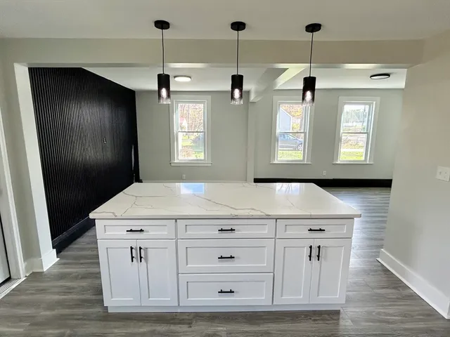 a kitchen with a stove and a wooden floor