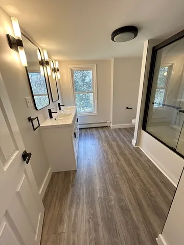 a view of a hallway with wooden floor and stairs
