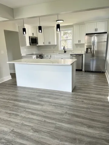 a view of kitchen with stainless steel appliances granite countertop a stove a sink and a refrigerator