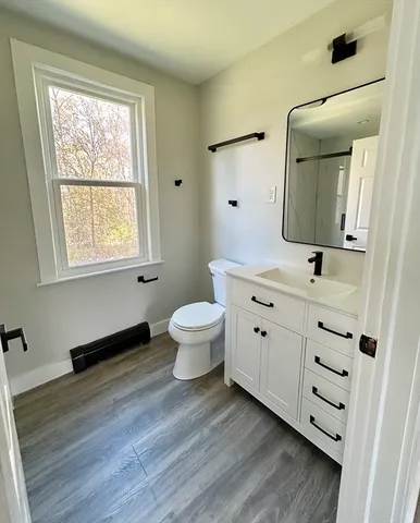 a bathroom with a toilet sink and mirror