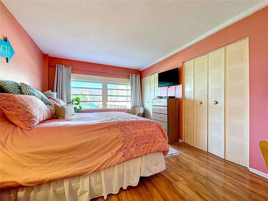 4650 Cove Circle, Unit 209 St. Petersburg, FL 33708 - Photo 11 of 54 a bedroom with a bed and wooden floor