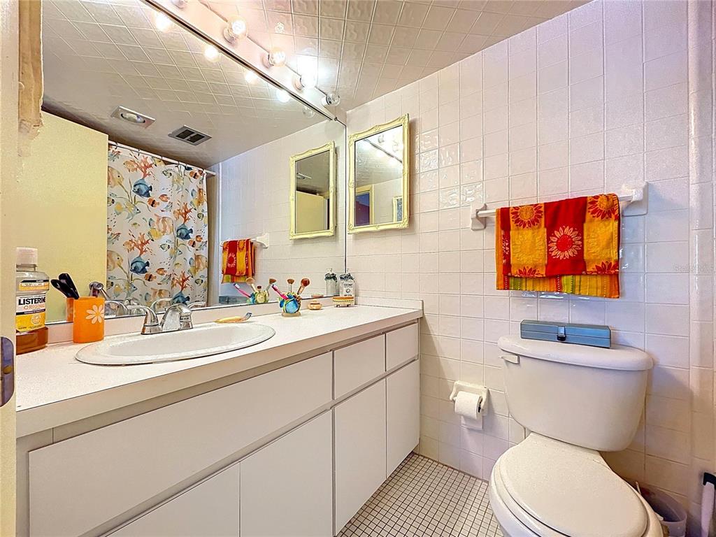 4650 Cove Circle, Unit 209 St. Petersburg, FL 33708 - Photo 14 of 54 a bathroom with a toilet sink and mirror