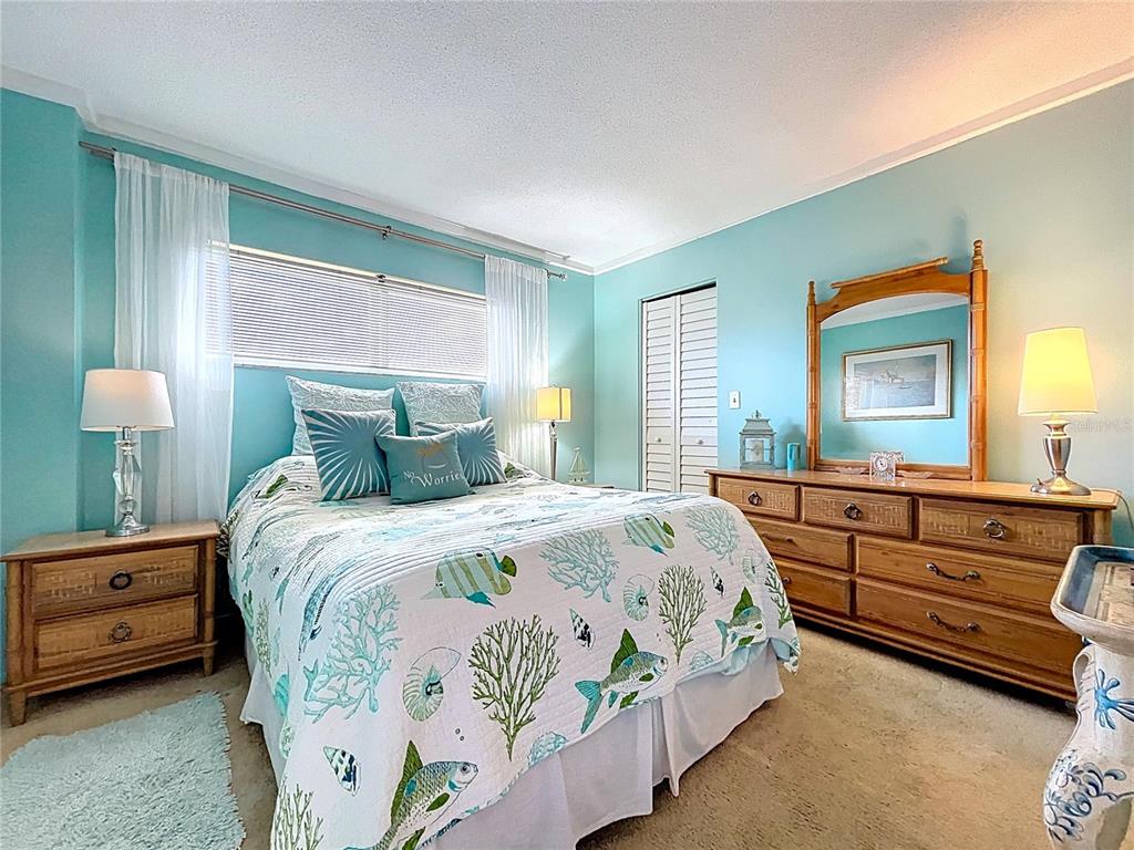 4650 Cove Circle, Unit 209 St. Petersburg, FL 33708 - Photo 16 of 54 a bedroom with a bed and a dresser