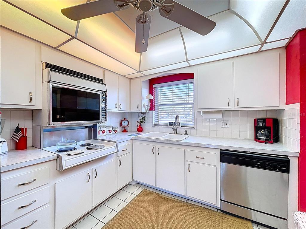 4650 Cove Circle, Unit 209 St. Petersburg, FL 33708 - Photo 4 of 54 a kitchen with stainless steel appliances granite countertop a sink and cabinets