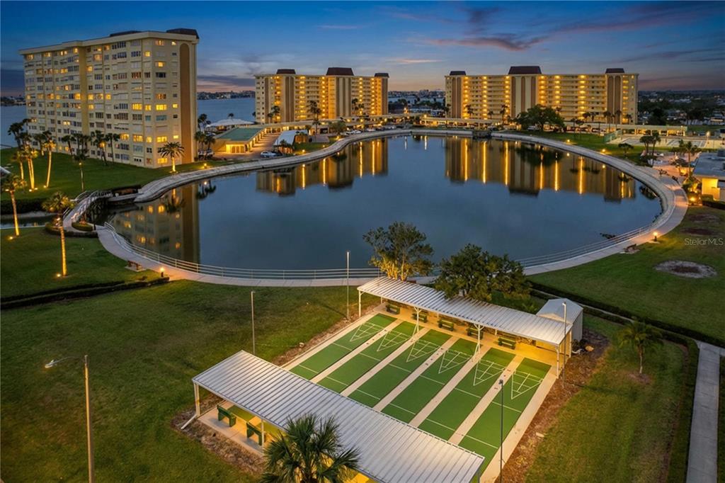 4650 Cove Circle, Unit 209 St. Petersburg, FL 33708 - Photo 41 of 54 a view of swimming pool with outdoor seating and yard