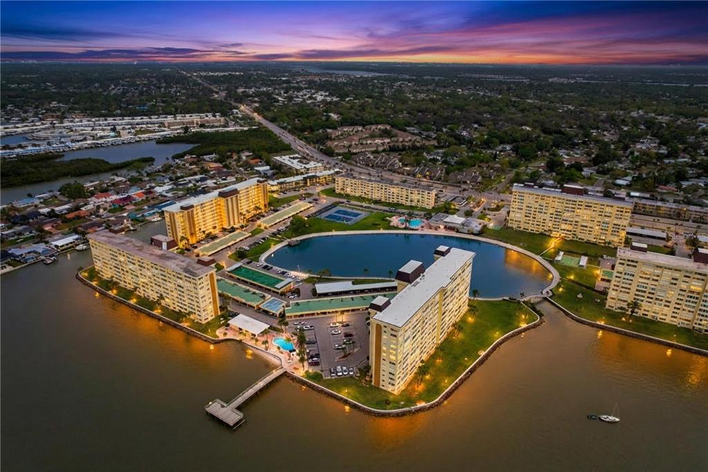 4650 Cove Circle, Unit 209 St. Petersburg, FL 33708 - Photo 49 of 54 a view of a swimming pool with a table and chairs