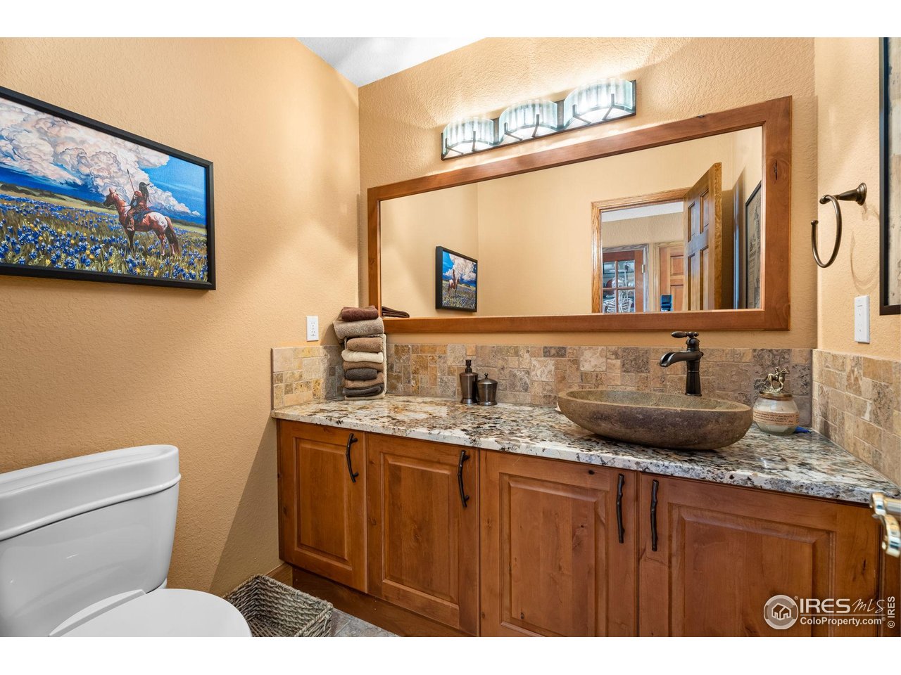 12625 Vermillion Road Longmont, CO 80504 - Photo 17 of 50 a bathroom with a granite countertop sink a mirror and a toilet